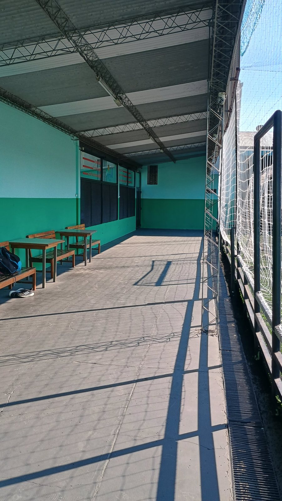 Galería con bancos junto a la cancha